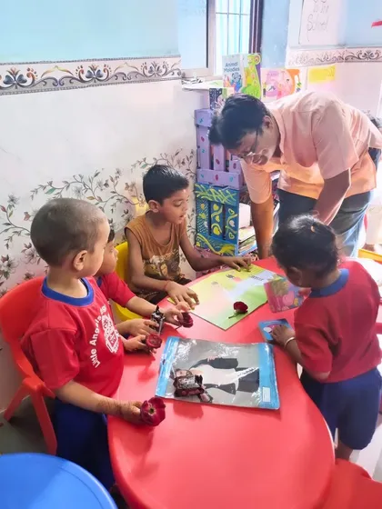 A volunteer helps children at the REAP Center explore their new storybooks. These moments of guided discovery are key to building early literacy skills.