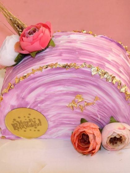 Our take on the trendy "top forward" cake style, with a beautiful purple marble effect, gold leaf, and fresh flowers.