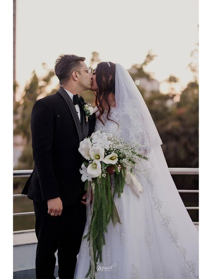 A classic wedding portrait: the kiss. This timeless shot captures the peak of romance for the newly married couple.