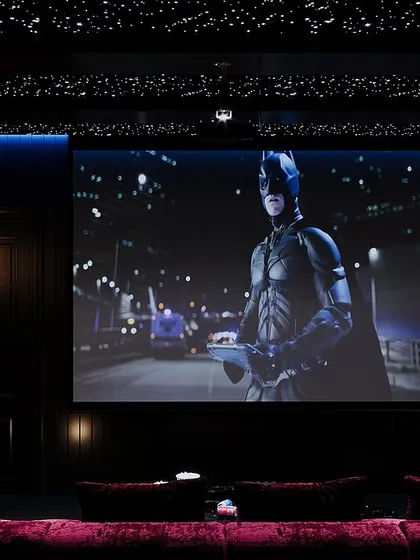 Transform your movie nights with a custom-designed home theatre. This one features grey and maroon tones, a cozy lounge sofa, and a star-like ceiling for the perfect cinematic ambiance. It's more than a space; it's an experience.