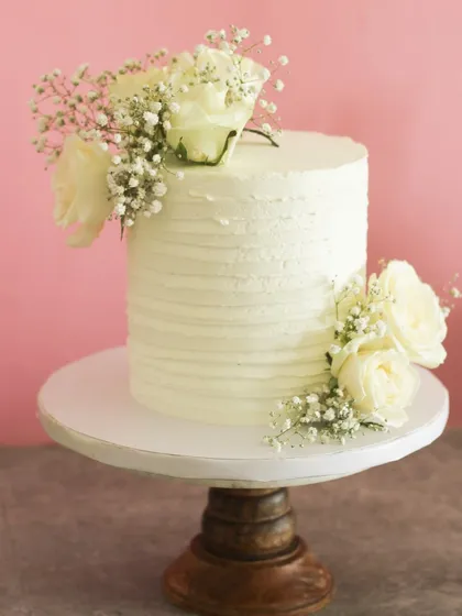 Celebrating with beautiful simplicity. This is my classic chocolate cake, frosted with whipped cream and adorned with fresh white florals for a clean, minimalist look.