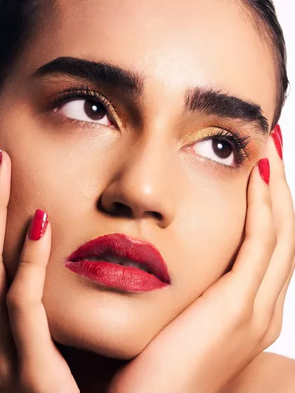 A slightly different angle, looking up, which highlights the golden eyeshadow and the precise application of the lipstick. It's a look of pure, polished elegance.