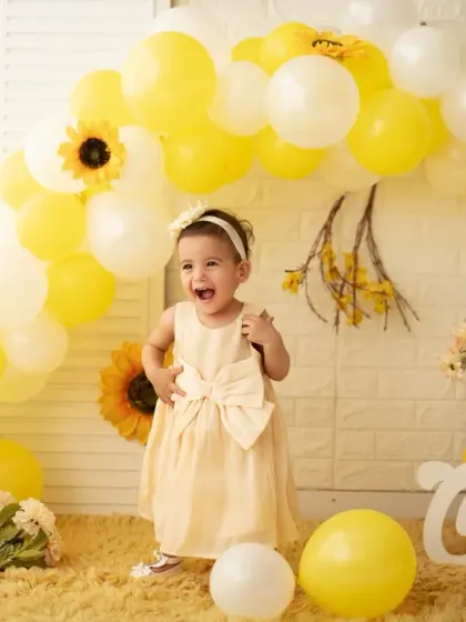 An expressive, happy moment from the yellow-themed first birthday session. We aim to capture the genuine joy of your child's special day.