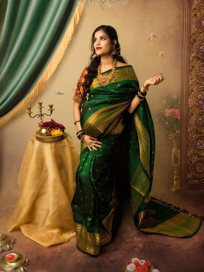A confident and graceful standing portrait of a mother-to-be. Her pose and the flow of the green saree create a look of timeless beauty and strength.