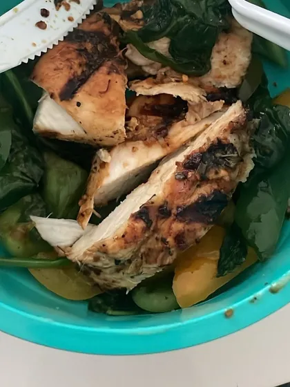 A close-up of sliced grilled chicken on a bed of greens. This meal is perfect for fat loss, providing high protein to keep you full and satisfied.