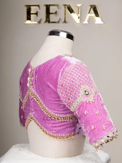 I love blending contemporary design with timeless fabrics. This lavender velvet blouse features a modern jewelry-like embellishment on the sleeves, with a mix of lattice work, pearls, and a central emerald-green stone.
