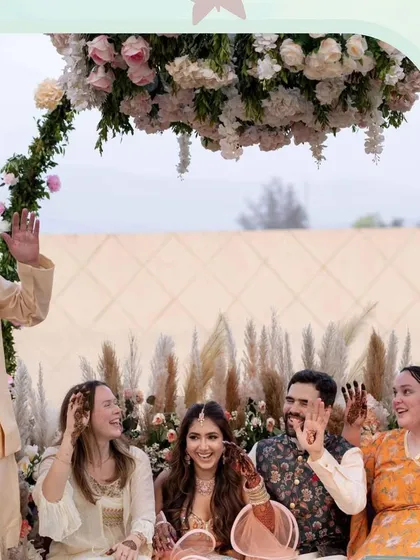 A happy moment with the bride and her loved ones at the Mehendi. We focus on creating beautiful settings, like this one with pampas grass and floral arrangements, for perfect group photos.