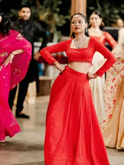 A modern Sangeet look featuring a sleek high ponytail and a bold red lip. This style is chic, comfortable, and perfect for a bride who wants to dance the night away.