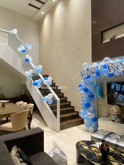 Decorating the entire home for a baby's arrival, including a simple yet elegant balloon garland running along the staircase railing.