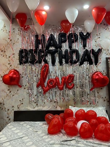 This is a popular birthday decoration theme using a black, red, and white color palette. I set up a silver fringe curtain as a backdrop for the 'Happy Birthday' foil balloons, with additional 'Love' and heart-shaped balloons to complete the romantic birthday surprise.