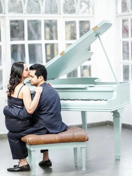 A romantic pre-wedding photo featuring a piano. This setup adds a touch of classic elegance and provides a unique prop for the couple's portraits.