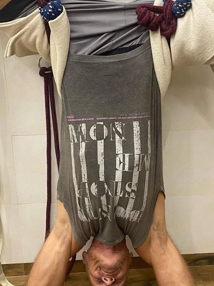 A supported headstand variation using wall ropes. The ropes take the pressure off the neck and shoulders, allowing the student to hold the inversion for a longer duration and focus on spinal alignment.