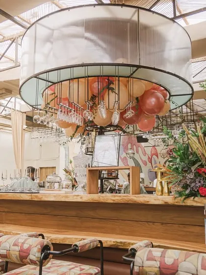 A view of the bar area, decorated with hanging balloons and lush floral arrangements to match the woodland theme.