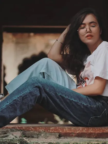We used a stone window at a heritage site in Bharatpur as a natural frame for this lifestyle fashion shot. The model's relaxed, seated pose and casual outfit contrast beautifully with the ancient architecture, creating a modern vintage look.