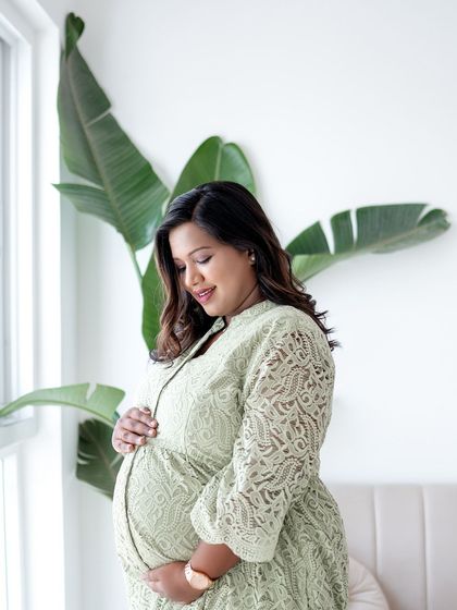 Another angle from a natural light maternity session. The focus is on the mother's serene expression as she connects with her baby.