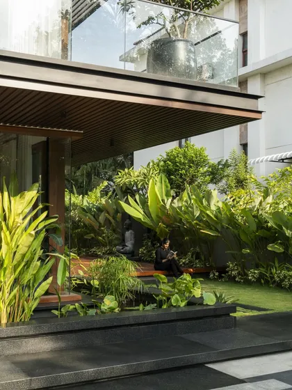 We designed quiet, contemplative spaces where the residents can connect with nature. This seating nook is nestled amidst lush greenery, sheltered by the overhead balcony, creating a perfect fusion of architecture and landscape.
