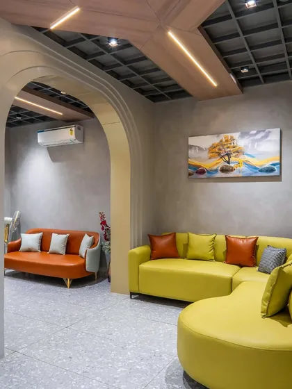 The informal waiting area, featuring brightly colored curved sofas and an arched entryway. This space is designed to be welcoming and comfortable for visitors.