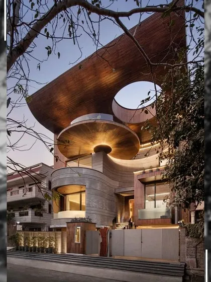 The facade of the Nadhyavart residence is a play of bold curves, geometric shapes, and natural materials. The circular overhangs and cut-outs create a sense of motion, making the building feel alive and dynamic within its urban setting.