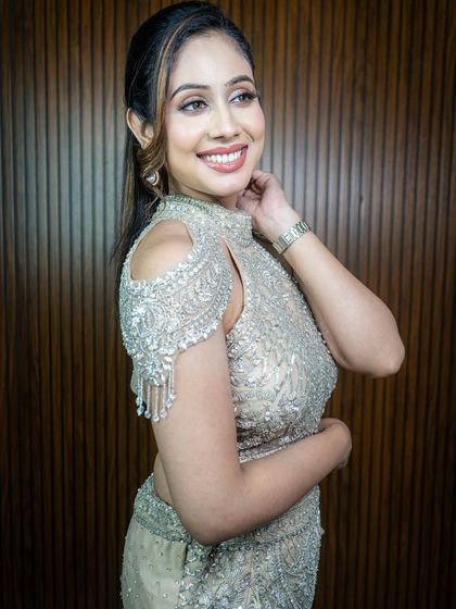 The fringed detailing on the sleeves adds a playful yet elegant touch to this glamorous reception gown.