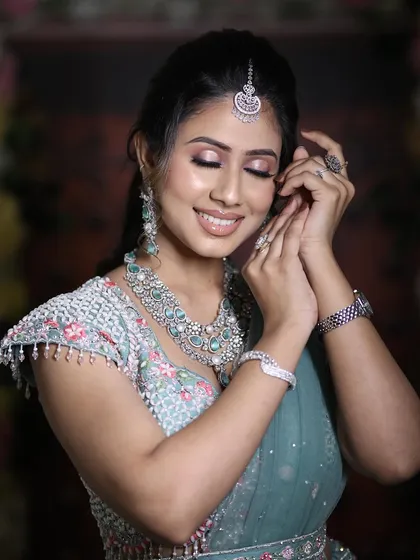 A close-up of a bride radiating happiness. Her pastel blue-green lehenga is paired with a stunning layered zircon necklace, proving that modern brides can sparkle just as brightly.