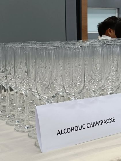 A lineup of champagne flutes ready for the alcoholic champagne service at a corporate event.