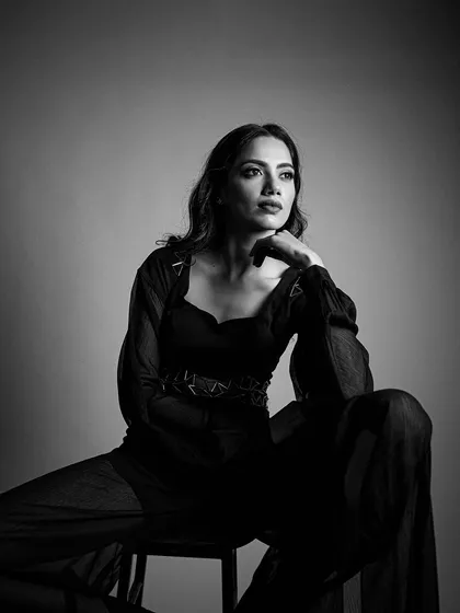 A pensive, artistic shot. The lighting and makeup work together to create a sense of drama and sophistication.