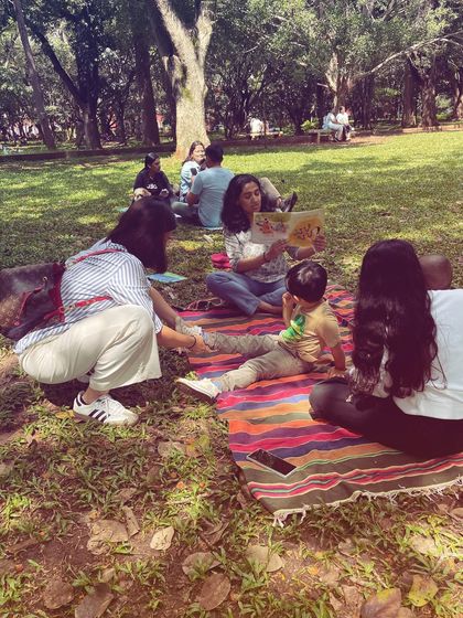 A quiet moment of reading to a small, focused group. Even when some kids are off playing, others find a calm space to connect with a book, showing how our sessions cater to different moods and needs.