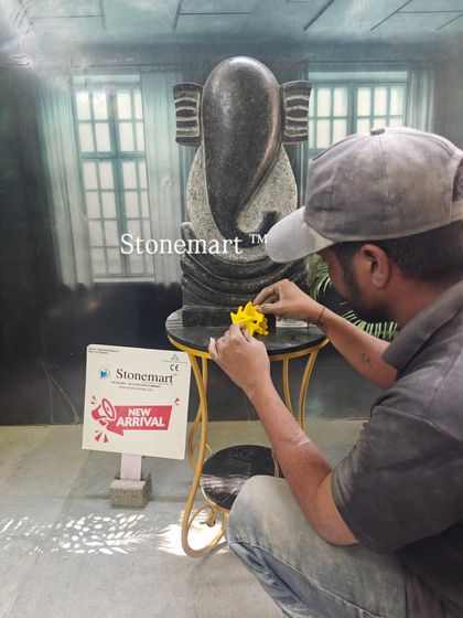 An artisan adds a final touch to the black granite Ganesha sculpture. This shows the hands-on care and attention to detail that goes into every piece we create.