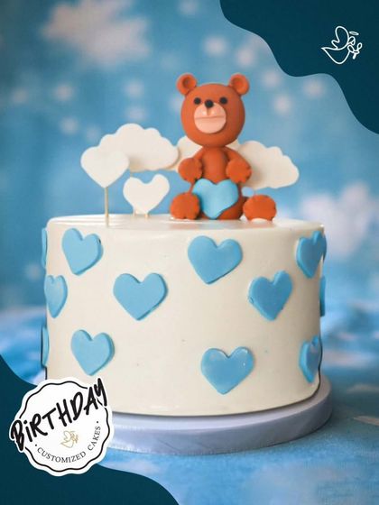 A sweet teddy bear cake with angel wings and blue hearts. This heavenly design is perfect for a precious little one's birthday or baby shower.