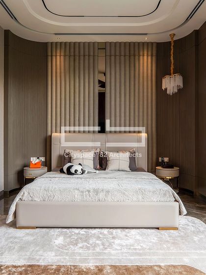 This luxurious bedroom retreat features a plush upholstered headboard and whimsical elements that add a cozy charm. Vertically ribbed paneling and sleek nightstands bring a contemporary flair, while a gold pendant light enhances the elegant ambiance.