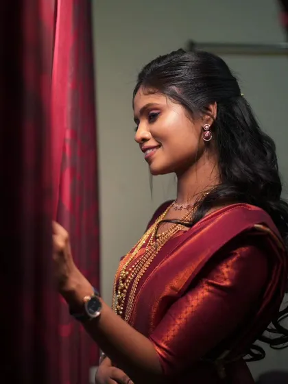 A beautiful reception look with a rich maroon saree and soft, flowing hair.