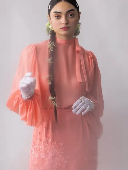 A full-length look from a poetic, botanical-inspired series. The combination of a high-neck blouse, floral-embellished skirt, and lace gloves creates a narrative of fragility and strength, styled to feel timeless and mysterious.