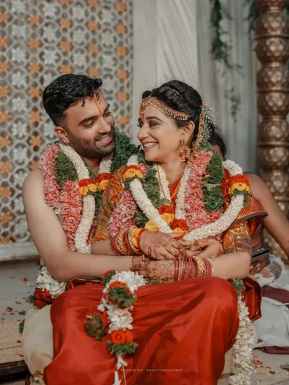 The couple shares a joyful, candid moment during their ceremony, their smiles reflecting the happiness of their union.