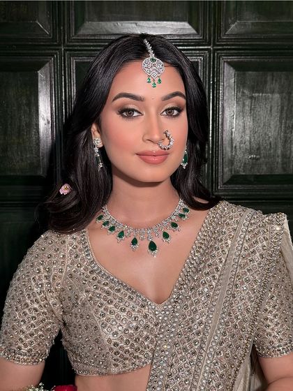 A classic portrait that highlights the elegant makeup. The winged eyeliner and neutral tones are perfect for a sophisticated guest who wants to look polished and chic.