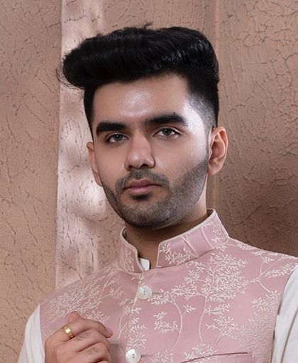 A close-up portrait highlighting the fine hook embroidery on our rose pink bundi jacket. The subtle texture and tonal work exemplify our focus on understated luxury.