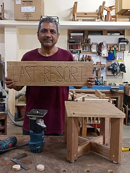 Dev with a stool he made using only hand tools, and a nameboard for his farmhouse. The lettering on the board was carved using a V-shaped router bit.