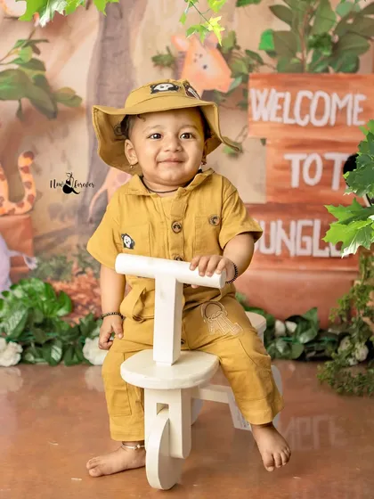 Our little jungle explorer is ready for an adventure! The safari outfit and his confident pose on the tricycle are perfect for this wild theme.