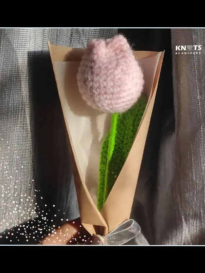 A single pink crochet tulip, elegantly wrapped. It's a simple, beautiful, and timeless gift.