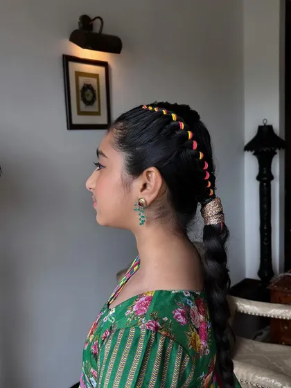 A close-up side view of the colorful threaded braid. The craftsmanship is evident in the neat weaving of the threads.