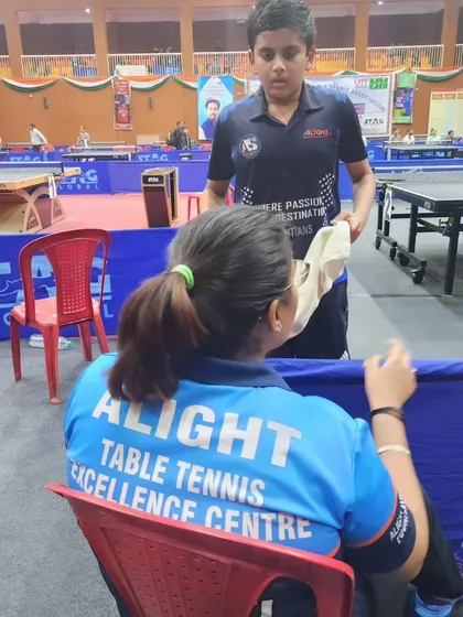 A coach's guidance during a tough match at the National Ranking tournament in Kangra. These moments are crucial for a player's development.