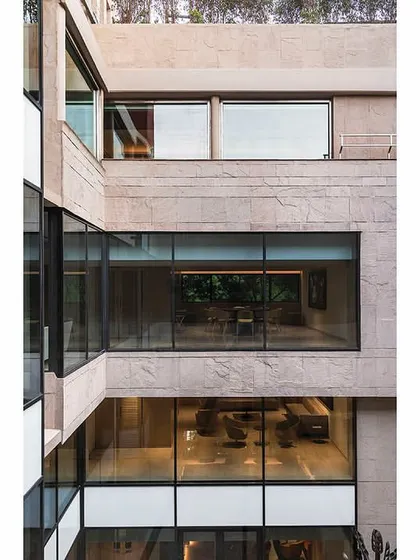 The multi-story glass walls of the central courtyard allow for clear views across different office floors, fostering a sense of openness and connection.