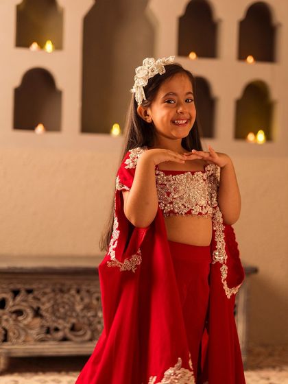 This vibrant red cape set features a beautifully embroidered crop top and comfortable pants, perfect for the festive season.