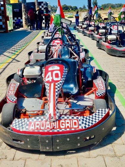 Our karts are lined up with flags, ready for a day of racing. We're open today, but closed tomorrow for a private event, so plan accordingly.