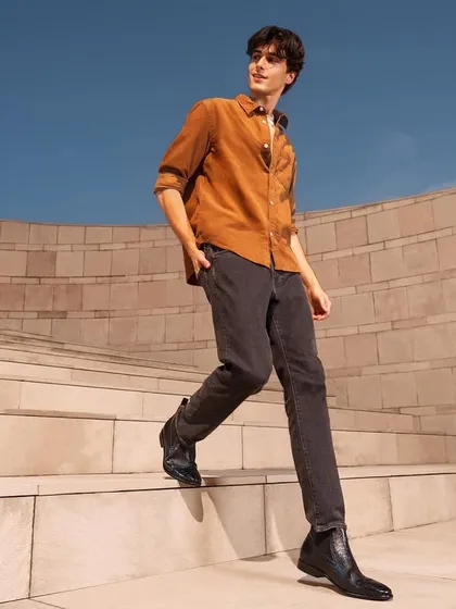 A dynamic shot from a commercial campaign for a shoe brand. The styling is casual and youthful, and the walking pose is designed to feel natural and energetic, highlighting the footwear in motion.