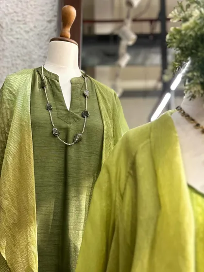 A closer look at this olive green tunic with a notched neckline, paired with a simple stone necklace for an earthy, grounded look.