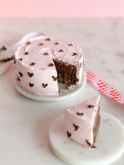 A slice of love. This mini heart cake, with its pink frosting and tiny chocolate hearts, is perfect for a Valentine's treat for two.