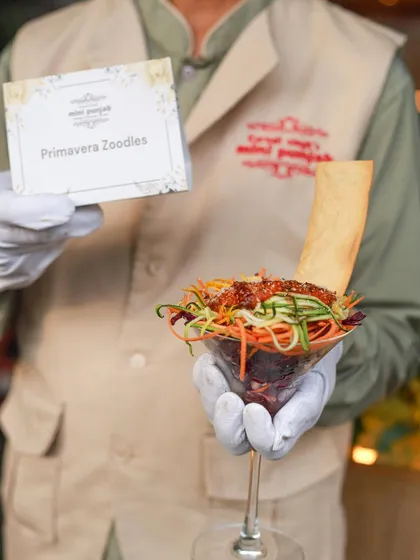 Our Primavera Zoodles, served in an elegant martini glass, are a healthy and stylish starter. This dish combines fresh vegetable noodles with a zesty dressing.
