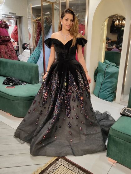 From the fitting room to a fairytale. This client looks like a princess in a black off-shoulder ball gown with a sparkling, multi-color gradient skirt.