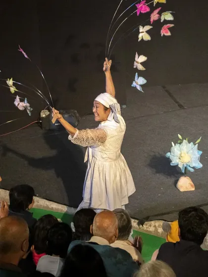 The performer from 'Puppet Fantasy' brings her butterflies close to the audience, sharing the magic with them directly.
