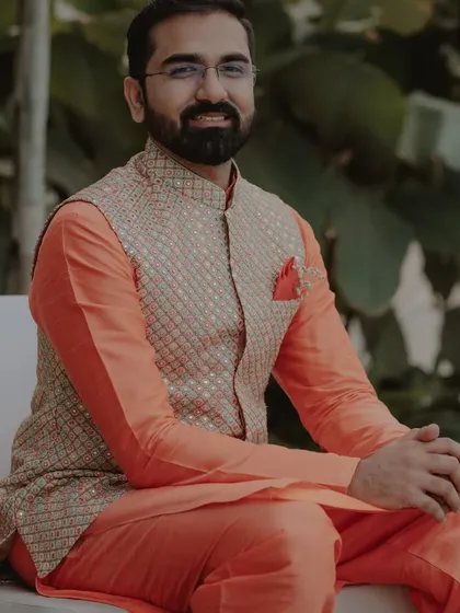 This is a great option for a Mehendi or Haldi function. The outfit consists of a bright orange silk kurta paired with a custom-embroidered bandi jacket, creating a look that is both festive and comfortable.